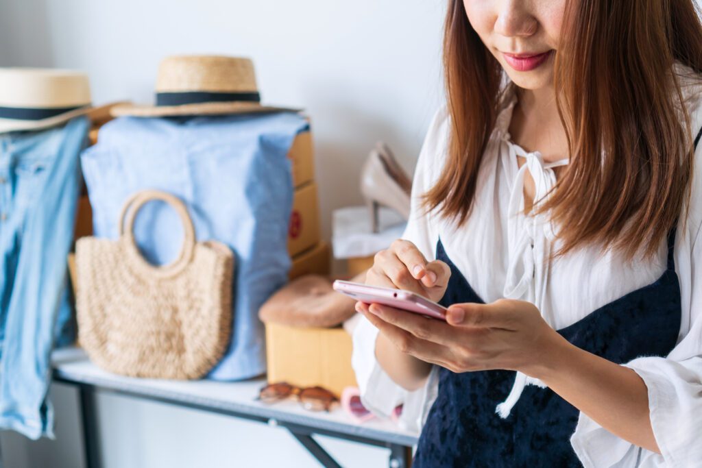 young asian business entrepreneur chatting with customer via smartphone